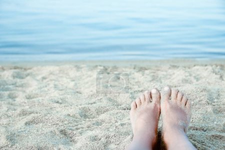 Téléchargez les photos : Belles jambes sur le sable au bord de la mer - en image libre de droit