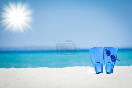Téléchargez les photos : Pantoufles sur le sable de la mer fond de voyage de la côte - en image libre de droit