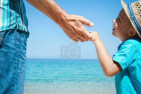 Téléchargez les photos : Mains d'un parent heureux et enfant au bord de la mer dans la nature Voyage - en image libre de droit