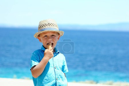 Foto de Niño feliz con helado junto al mar en fin de semana viaje orilla - Imagen libre de derechos