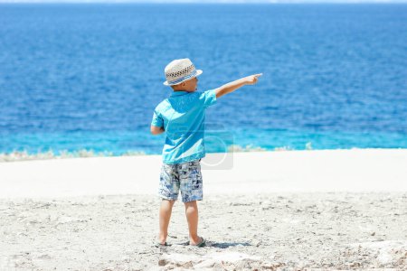 Photo for Happy child near the sea in nature on a weekend trip - Royalty Free Image