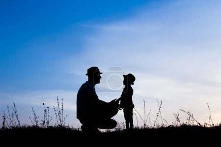 Foto de Padres felices con niños jugando en la silueta de verano de la naturaleza - Imagen libre de derechos