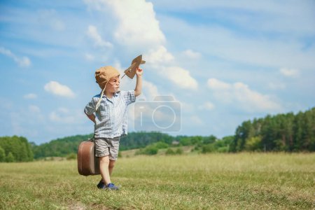 Photo for Baby boy by the plane plays on nature in the park. Boy on vacation pilot. - Royalty Free Image