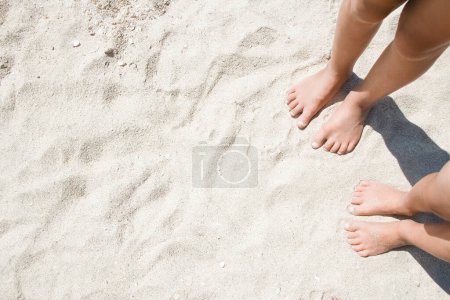 Téléchargez les photos : Pieds sur le sable des gens heureux au bord de la mer sur la nature Voyage - en image libre de droit