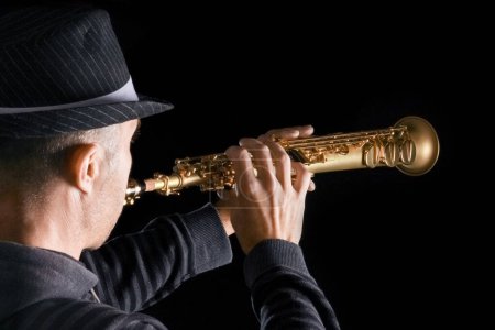 Foto de Saxofón soprano en las manos de un chico sobre un fondo negro - Imagen libre de derechos