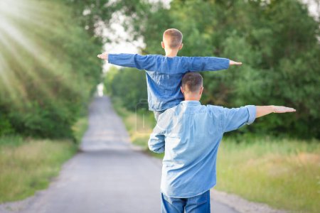 Téléchargez les photos : Happy child on the shoulders of a parent in nature on the way to travel - en image libre de droit