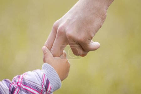 Téléchargez les photos : Mains Les parents heureux et l'enfant à l'extérieur dans le parc - en image libre de droit