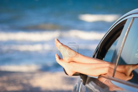 Téléchargez les photos : Fille heureuse dans la voiture par la mer dans la nature en voyage de vacances - en image libre de droit