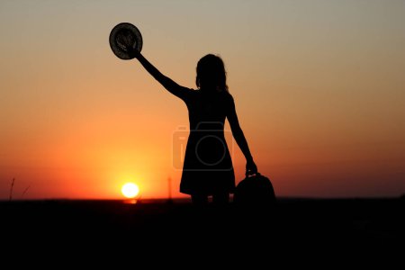 Photo for Happy girl with hat and chimodam silhouette at rpyrode in the park - Royalty Free Image