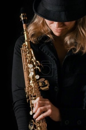 Foto de Saxofón soprano en manos de una chica sobre un fondo negro - Imagen libre de derechos