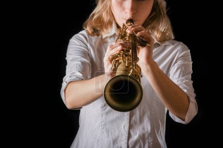 Téléchargez les photos : Saxophone soprano dans les mains d'une fille sur fond noir - en image libre de droit