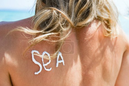Foto de Chica feliz en el mar con una foto del sol en su espalda - Imagen libre de derechos