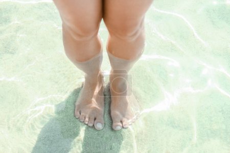 Foto de Hermosas piernas en la arena junto al mar griego - Imagen libre de derechos