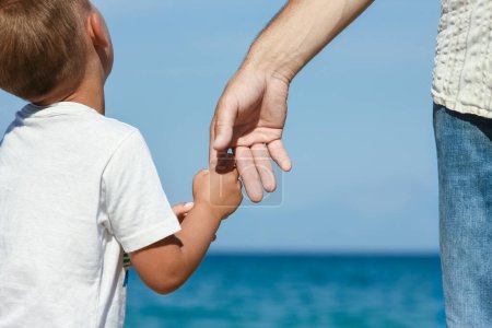 Photo for Happy dad holds the hand of a child by the greek sea in nature - Royalty Free Image