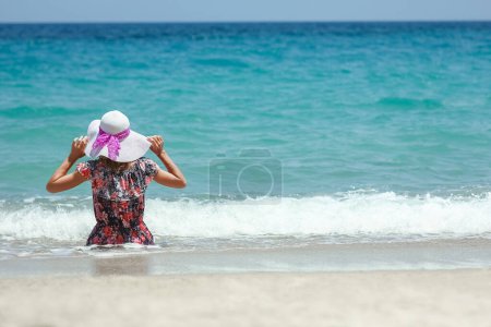 Foto de Happy girl on the shore of the sea in travel vacation - Imagen libre de derechos