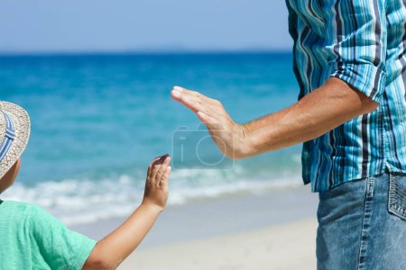 Photo for Hands of a happy parent and child on the seashore on a journey trip in nature - Royalty Free Image