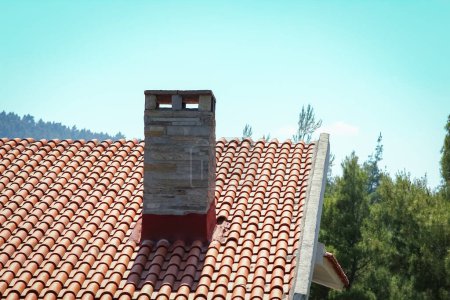 Téléchargez les photos : Chimney on the roof of the house in nature pollution ecology background - en image libre de droit