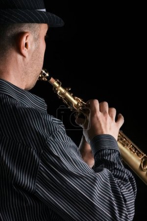 Foto de Saxofón soprano en las manos de un chico sobre un fondo negro - Imagen libre de derechos