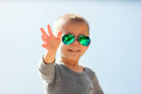 Foto de Niño feliz en gafas del sol en la naturaleza en el parque de viaje - Imagen libre de derechos