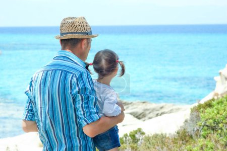Téléchargez les photos : Parent heureux avec enfant par la mer Grèce à l'extérieur - en image libre de droit