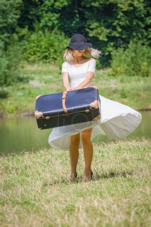 Téléchargez les photos : Fille heureuse avec une valise à l'extérieur au parc - en image libre de droit