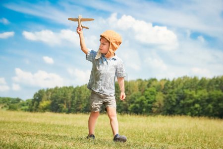 Téléchargez les photos : Bébé garçon par l'avion joue sur la nature dans le parc. Garçon en vacances pilote. - en image libre de droit