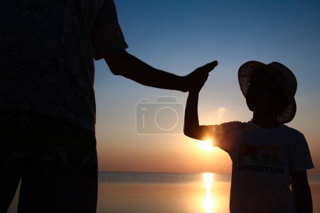 Photo for Hands of happy father and child by the sea on nature silhouette travel - Royalty Free Image