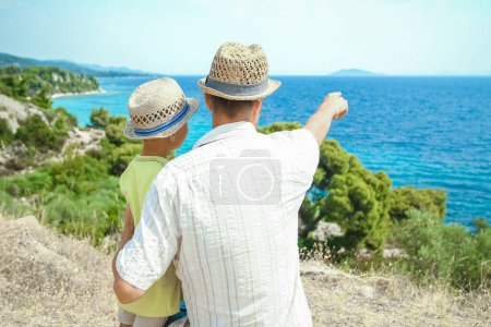 Téléchargez les photos : Mains de parents heureux et les enfants en mer en arrière-plan de voyage en Grèce - en image libre de droit