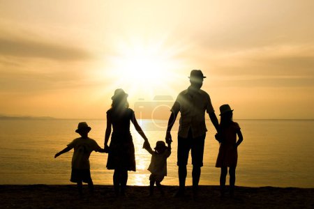 Téléchargez les photos : Famille heureuse dans la nature en bord de mer sur une silhouette de voyage - en image libre de droit