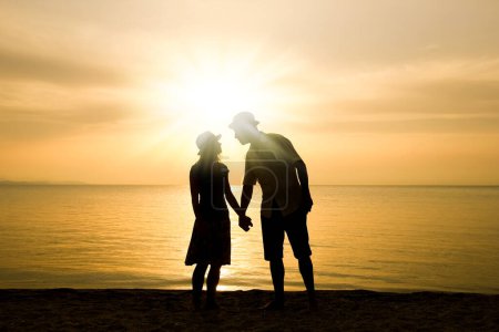 Téléchargez les photos : Couple heureux au bord de la mer sur la nature en silhouette de voyage - en image libre de droit