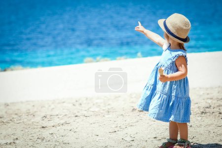Photo for Happy child with ice cream by the sea on weekend travel shore - Royalty Free Image