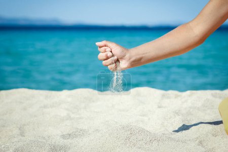 Hände schütten am Wochenende Sand in Küstennähe