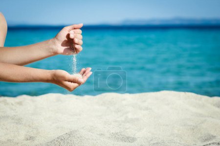hands pouring sand near the seashore on weekend nature travel