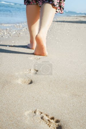 Téléchargez les photos : Belles traces avec pieds sur fond de mer nature - en image libre de droit