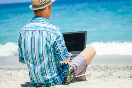 Téléchargez les photos : Happy man guy with laptop near the seashore weekend travel - en image libre de droit