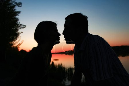 Foto de Silueta de pareja feliz contra un romance al atardecer - Imagen libre de derechos