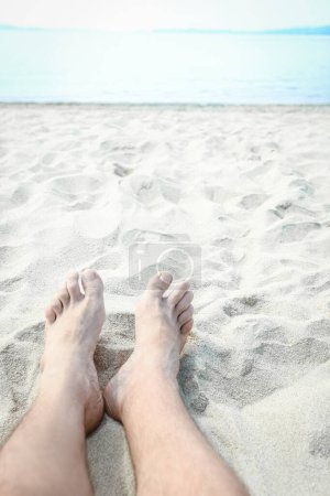 Téléchargez les photos : Belles jambes dans le sable de la mer fond grec - en image libre de droit