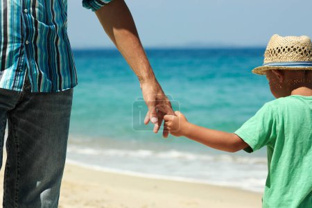 Photo for Hands of a happy parent and child on the seashore on a journey trip in nature - Royalty Free Image