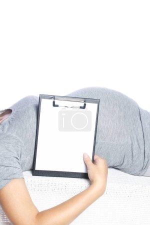 Téléchargez les photos : Heureuse fille enceinte repose sur fond blanc - en image libre de droit