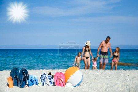 Photo for Happy family on the sea with slippers on nature background - Royalty Free Image