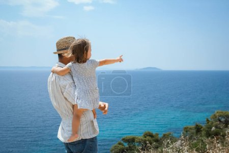 Téléchargez les photos : Mains de parents heureux et les enfants en mer en arrière-plan de voyage en Grèce - en image libre de droit