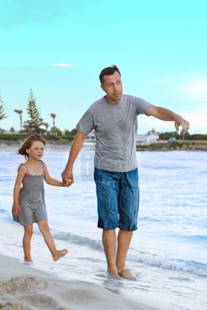 Téléchargez les photos : Parent heureux avec un enfant au bord de la mer en plein air - en image libre de droit
