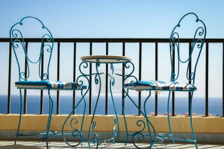 Téléchargez les photos : Magnifiquement élégantes chaises de table sur le fond de bord de mer - en image libre de droit