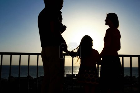 Foto de Familia feliz en el amanecer del fondo de la silueta del mar - Imagen libre de derechos