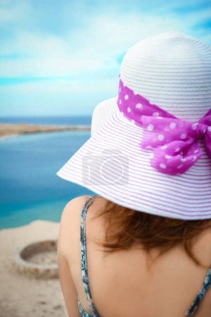 Foto de Elegante chica hermosa en sombrero en el fondo de la orilla del mar - Imagen libre de derechos