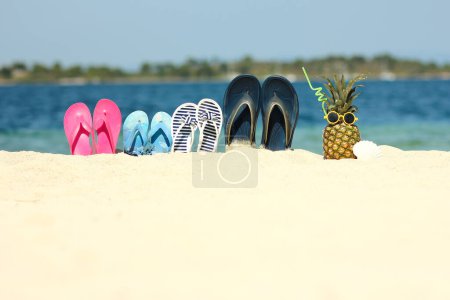 Photo for Pineapple in nature by the sea with sneakers on the shore nature background - Royalty Free Image