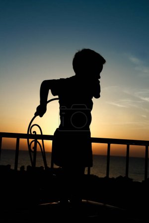 Photo for Happy child at the time of the silhouette of the sea background - Royalty Free Image