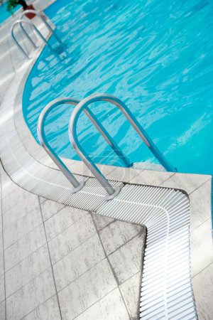 Foto de Elegante escalera hermosa en la piscina aceptada al aire libre en el parque de verano - Imagen libre de derechos