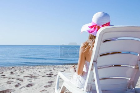 Téléchargez les photos : Heureuse fille dans une chaise longue sur la mer en été sur la nature - en image libre de droit
