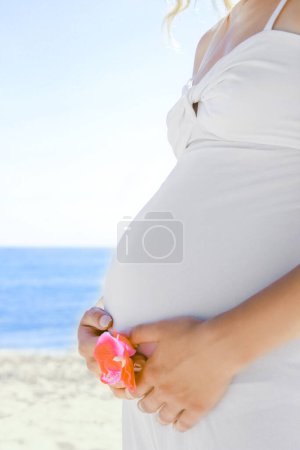 Foto de Feliz hermosa mujer embarazada en el mar en el verano en la naturaleza - Imagen libre de derechos